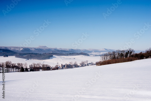 Beautiful winter landscape. Mountains in winter. The forest is covered with snow. Landscape for poster.Snowdrifts on winter snow covered mountainside and sun shine in blue sky.  © Dominika