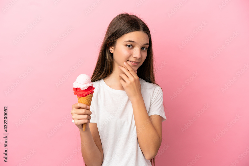 Little girl with a cornet ice cream over isolated pink background looking up while smiling Little girl with a cornet ice cream over isolated pink background looking up while smiling