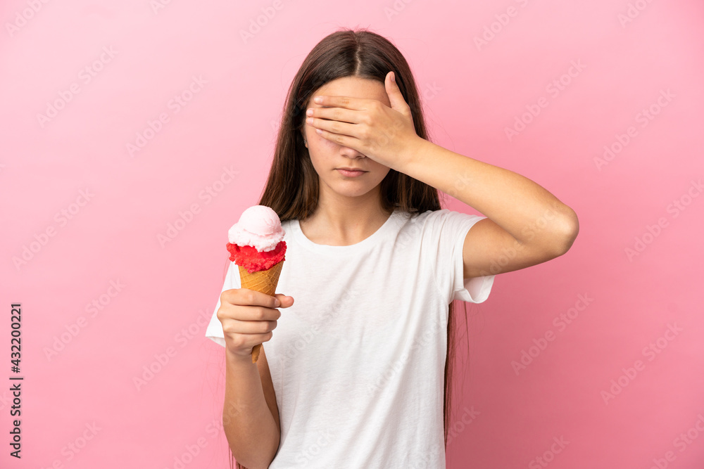 Little girl with a cornet ice cream over isolated pink background covering eyes by hands. Do not want to see something Little girl with a cornet ice cream over isolated pink background covering eyes by hands. Do not want to see something
