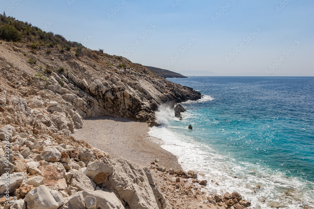 Small stone wild beach and turquoise sea, Albania. Travel and vacation theme, beautiful nature