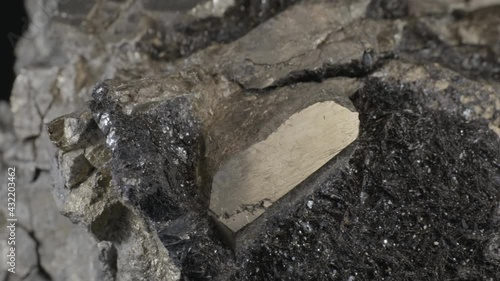 Pyrite dodecahedral crystals on hematite (also known as fool's gold or iron pyrite), isolated on a black background photo