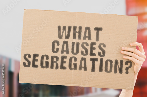 Billede på lærred The question  What causes segregation?  on a banner in men's hand with blurred background