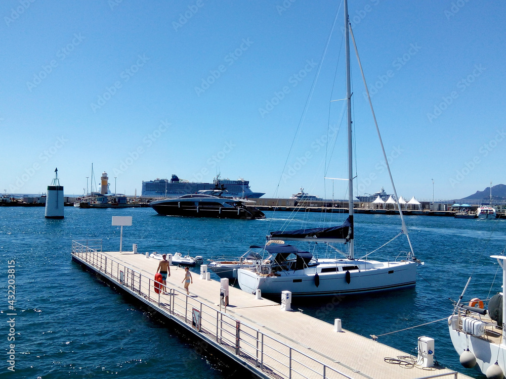 Fototapeta premium Sunny view of the port. Cruise liner in the harbor. Beautiful panoramic landscape on a sunny day. A wonderful trip to the Cote d'Azur in France. Scenic harbour view of the city of the sea country. 