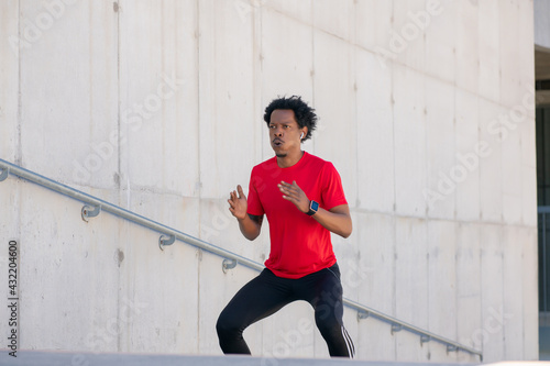 Afro athletic man doing exercise outdoors.