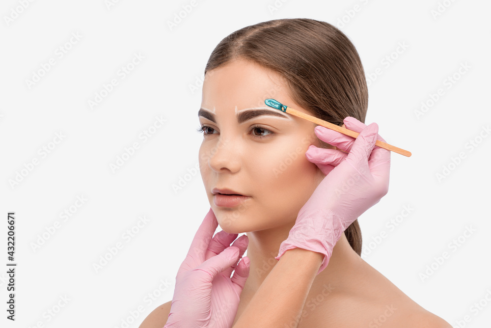 Makeup artist does facial hair removal procedure. Beautiful girl with blue eyes having Permanent Make-up on her Eyebrows. Professional makeup. Makeup artist does facial hair removal procedure. Beautiful girl with blue eyes having Permanent Make-up on her Eyebrows. Professional makeup.