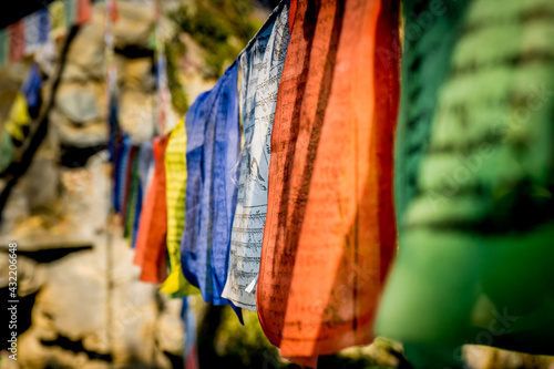 close-up view of tibetan prayer flags strung along a trail in the himalayas to bless the surrounding countryside