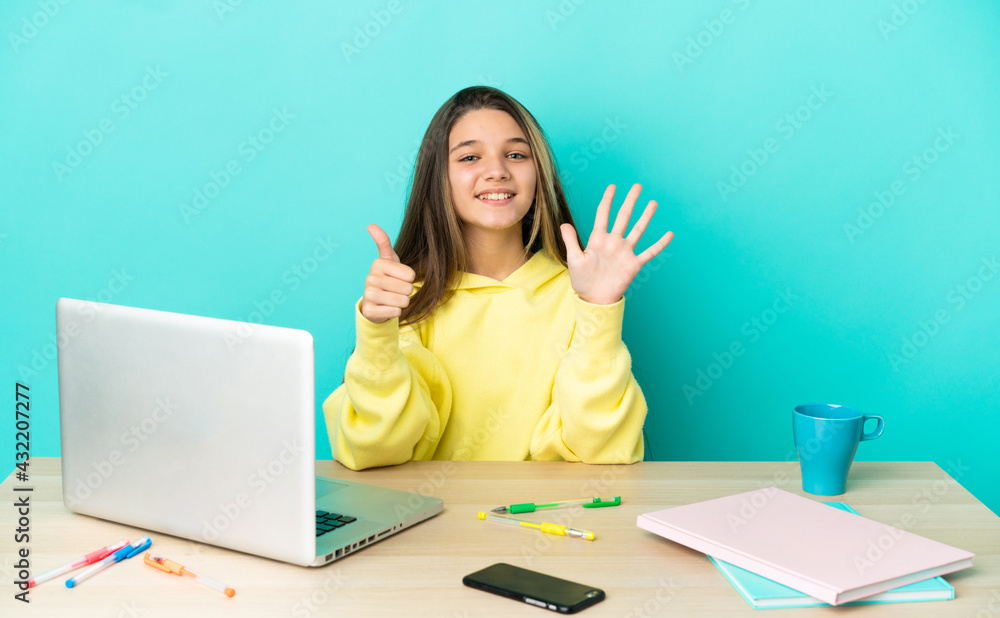 Little girl in a table with a laptop over isolated blue background counting six with fingers Little girl in a table with a laptop over isolated blue background counting six with fingers