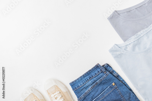 Flat lay summer composition with jeans and sneakers on a white background