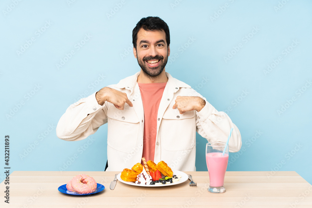 Man at a table having breakfast waffles and a milkshake with surprise facial expression Man at a table having breakfast waffles and a milkshake with surprise facial expression