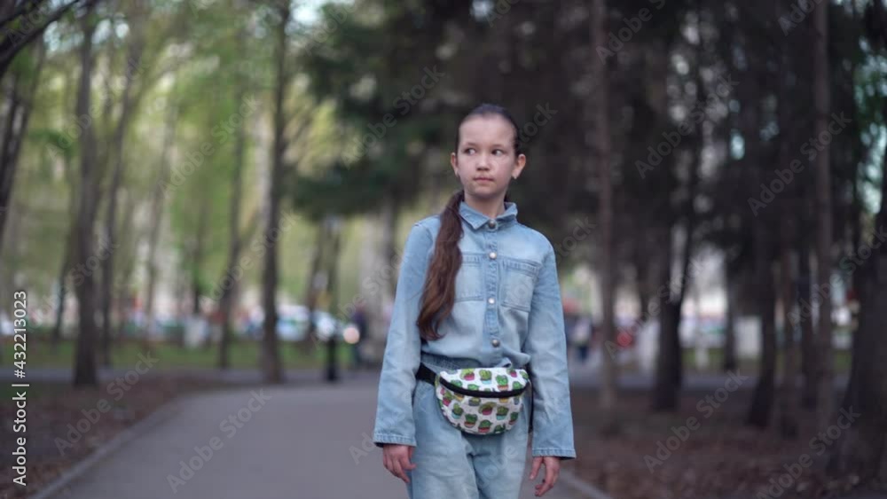 Fashionable girl travels through park streets on a skateboard Fashionable girl travels through park streets on a skateboard