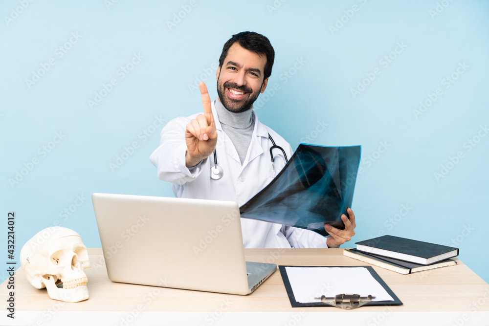 Professional traumatologist in workplace showing and lifting a finger Professional traumatologist in workplace showing and lifting a finger