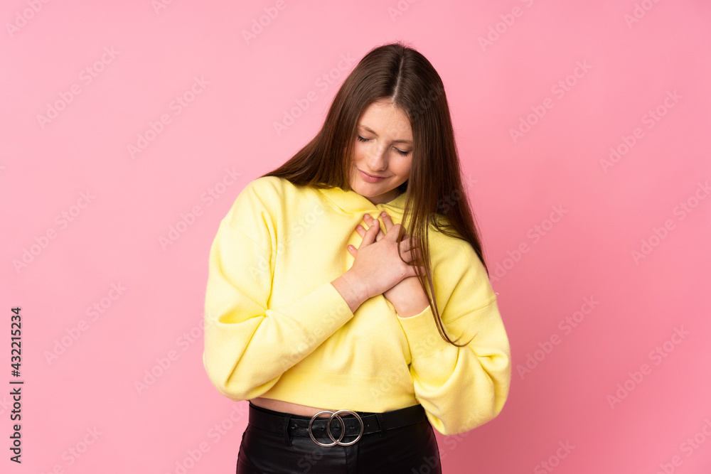 Teenager caucasian girl isolated on pink background having a pain in the heart Teenager caucasian girl isolated on pink background having a pain in the heart