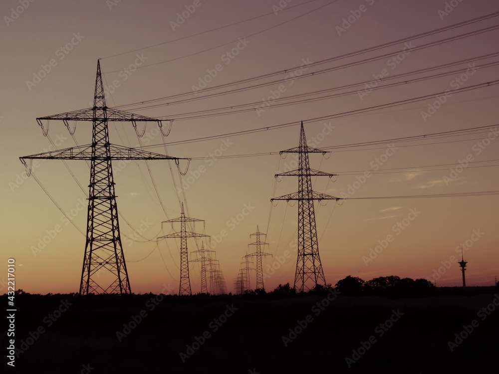 Strommasten und Energieleitungen in der Abenddämmerung