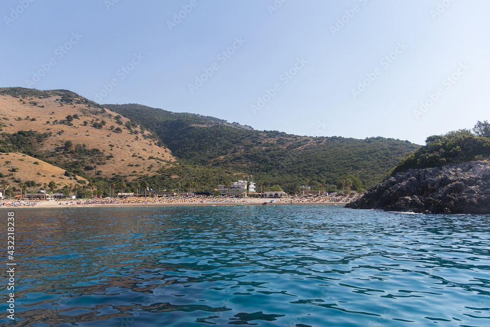 View of the strip of the sea, beach and mountains surrounded by vegetation, Albania. Travel and vacation theme