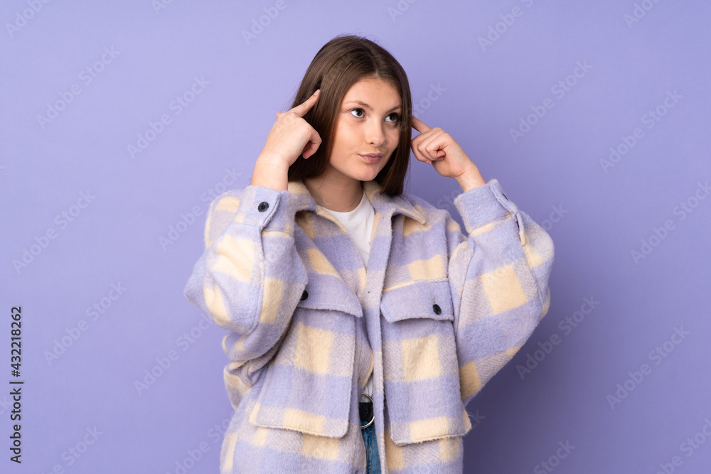 Teenager caucasian girl isolated on purple background having doubts and thinking Teenager caucasian girl isolated on purple background having doubts and thinking