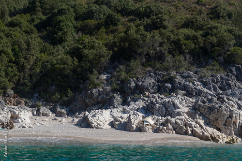 View of the strip of the sea, beach and rocks surrounded by trees, Albania. Travel theme