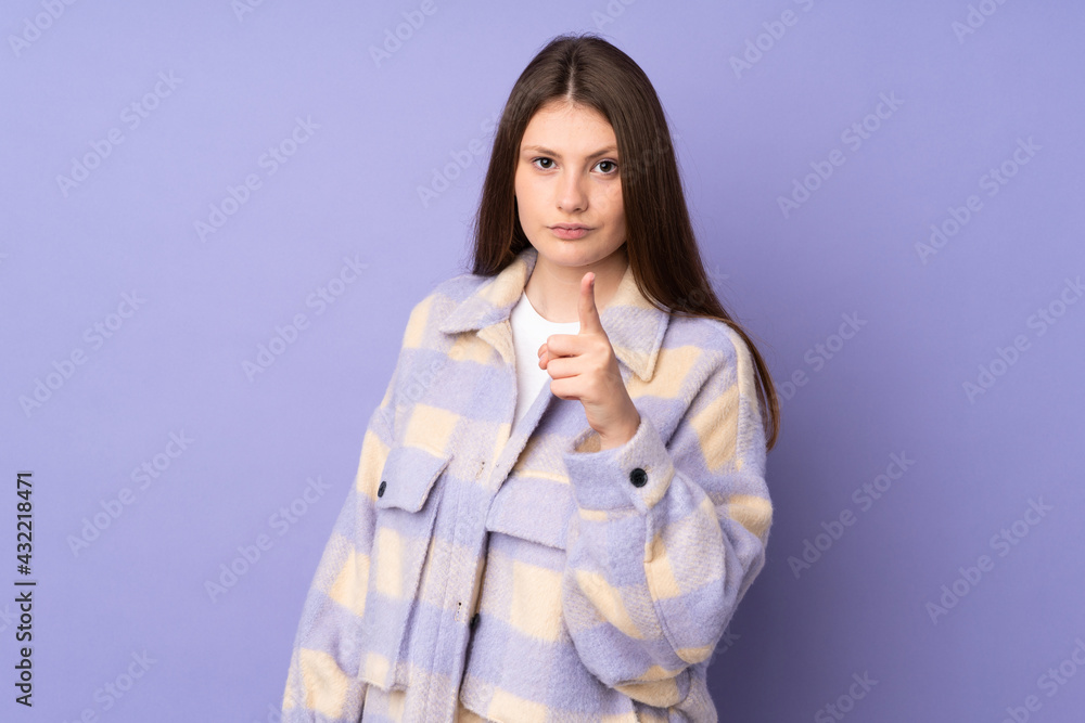 Teenager caucasian girl isolated on purple background frustrated and pointing to the front Teenager caucasian girl isolated on purple background frustrated and pointing to the front