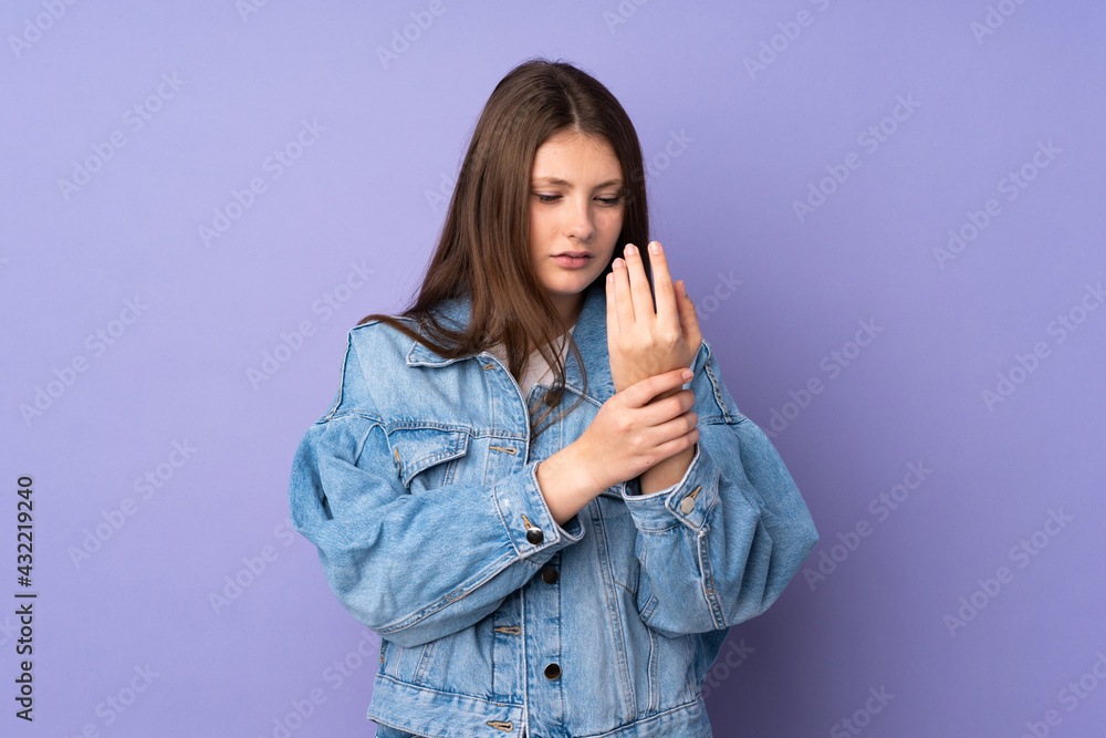 Teenager caucasian girl isolated on purple background suffering from pain in hands Teenager caucasian girl isolated on purple background suffering from pain in hands