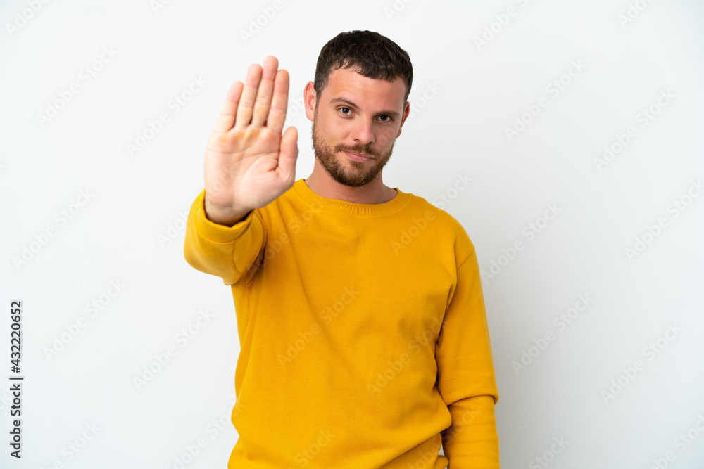 Young Brazilian man isolated on white background making stop gesture Young Brazilian man isolated on white background making stop gesture