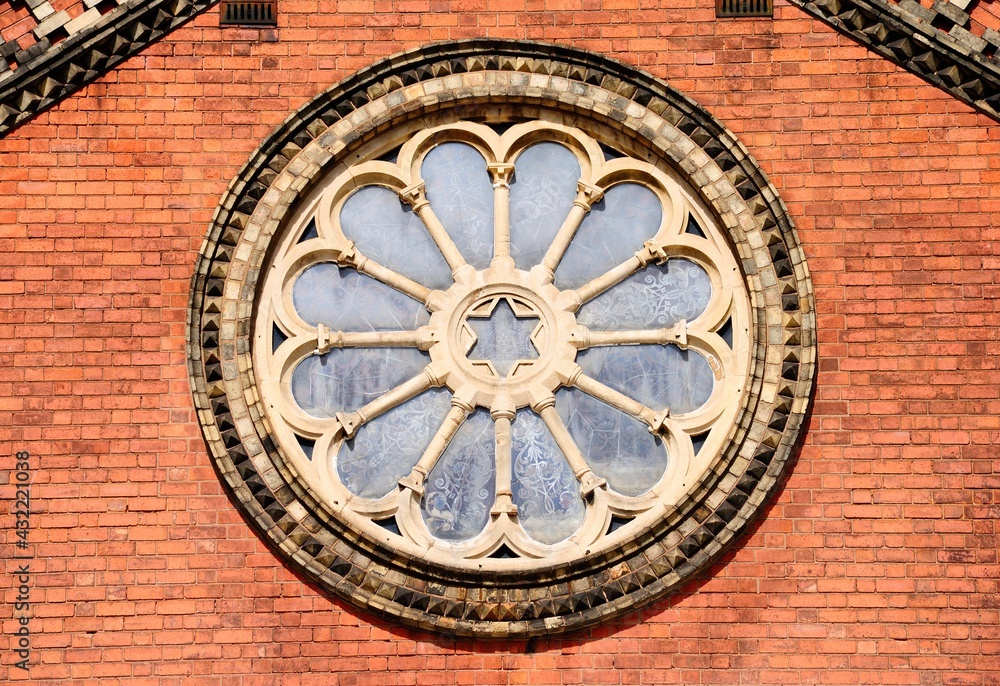 Red and yellow brick Norman-wheel window with Neo-classical, Romanesque, and Italianate details and the David star in the center in Birmingham, UK