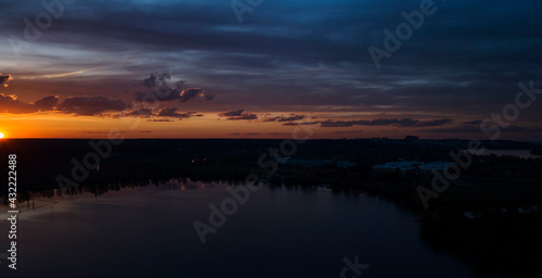 Beautiful sunset with clouds over the river under construction houses in the dark, Ukraine, Kiev on May 6.