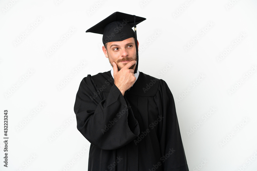 Young university Brazilian graduate isolated on white background looking up while smiling Young university Brazilian graduate isolated on white background looking up while smiling