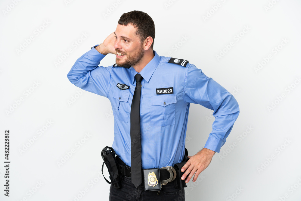 Young police Brazilian man isolated on white background listening to something by putting hand on the ear Young police Brazilian man isolated on white background listening to something by putting hand on the ear