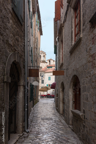 Narrow street with ancient stone pavers with medieval buildings in old european city Kotor in Montenegro