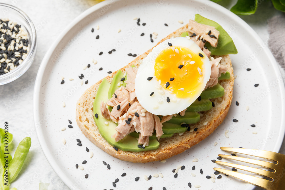 Avocado, canned tuna and boiled egg toast on white stone table background. Healthy food, avocado open sandwich for breakfast or lunch. Flat lay, top view, close up Avocado, canned tuna and boiled egg toast on white stone table background. Healthy food, avocado open sandwich for breakfast or lunch. Flat lay, top view, close up