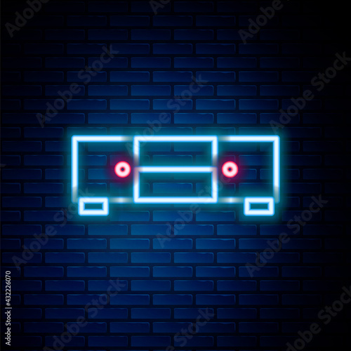 Glowing neon line Chest of drawers icon isolated on brick wall background. Colorful outline concept. Vector