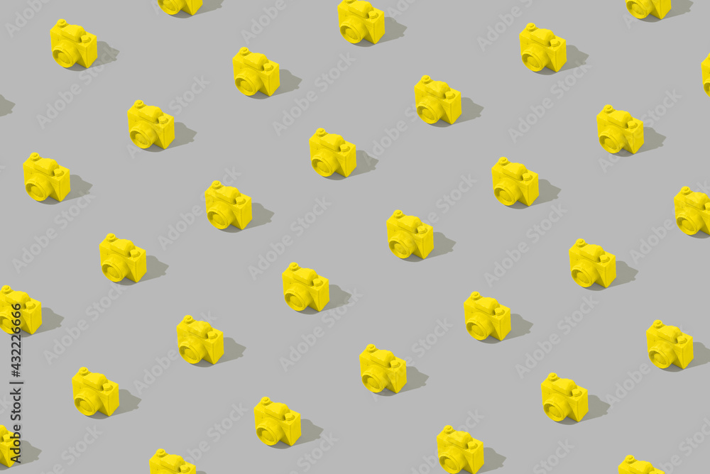 Modern sunlight pattern made of yellow analog camera on gray background. Modern sunlight pattern made of yellow analog camera on gray background.