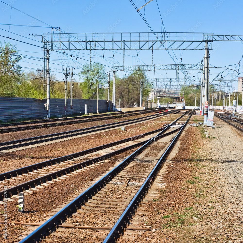 Railway lines at sunny day. Electricity poles and track line environment. Perspective sleepers and rails. Railway lines at sunny day. Electricity poles and track line environment. Perspective sleepers and rails.