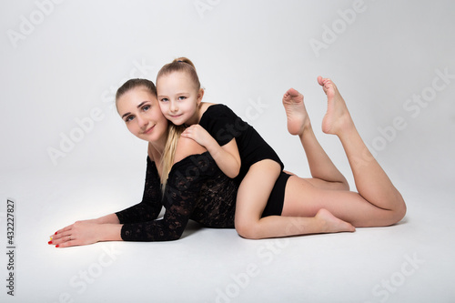 mom flexes in gymnastic position daughter hugs mom