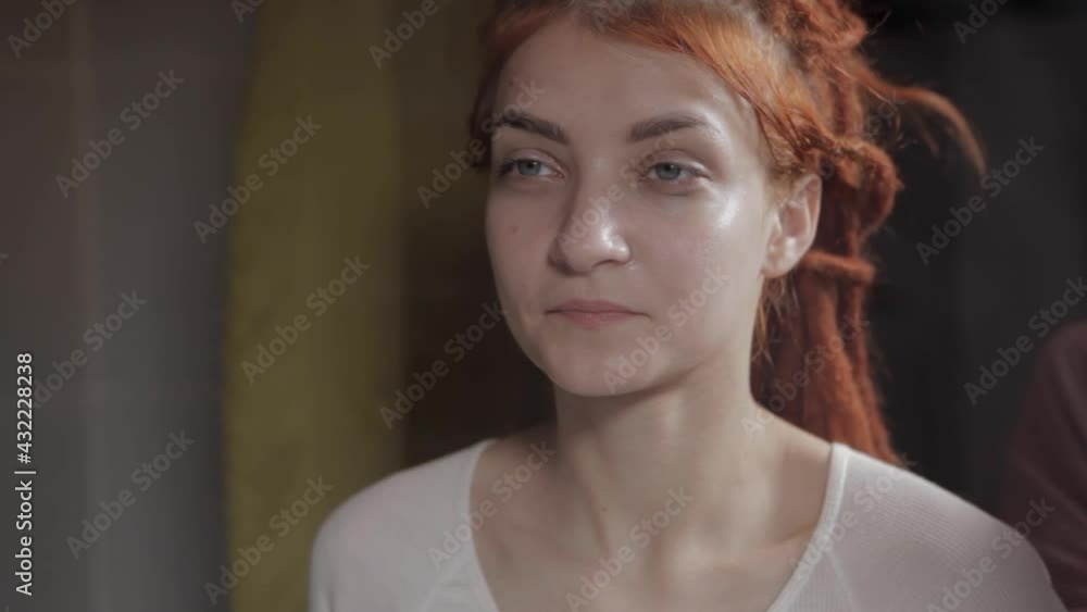 A woman washes her face. Daily hygiene procedures. A redhaired girl