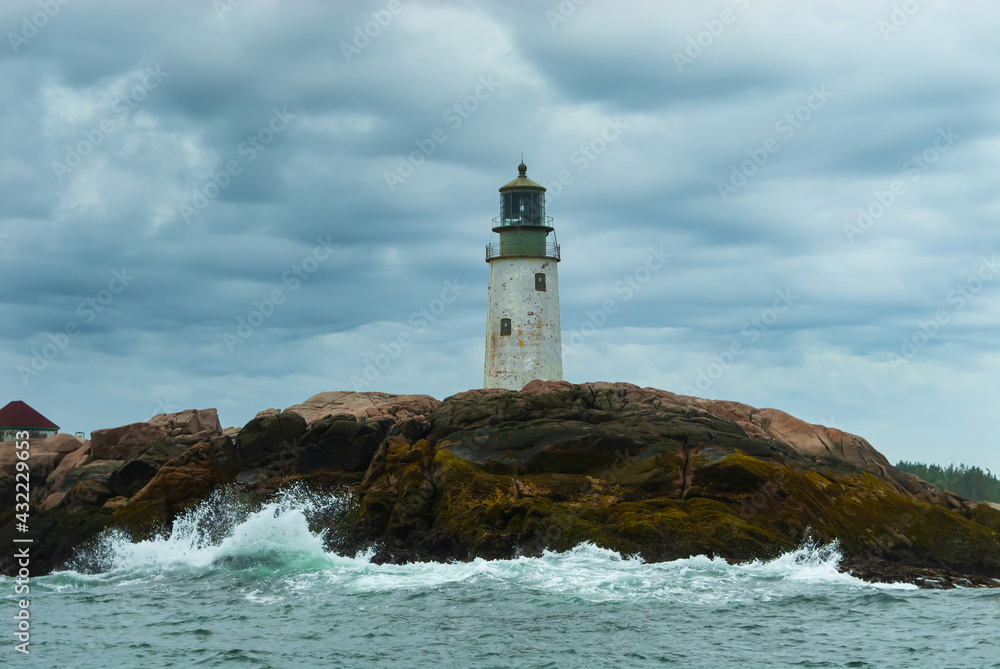 Waves Break By Old Lighthouse Tower on Cloudy Day in Maine