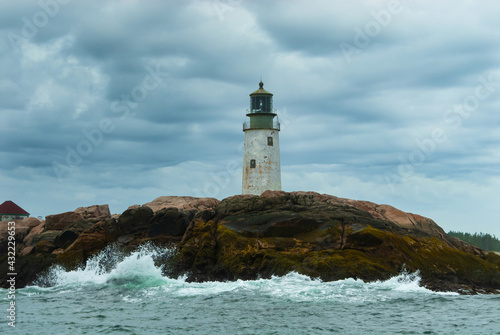 Waves Break By Old Lighthouse Tower on Cloudy Day in Maine