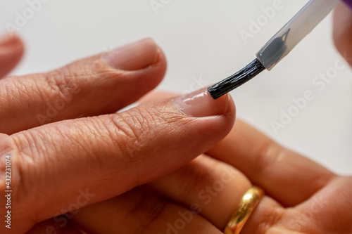Manicure paints nails with enamel
