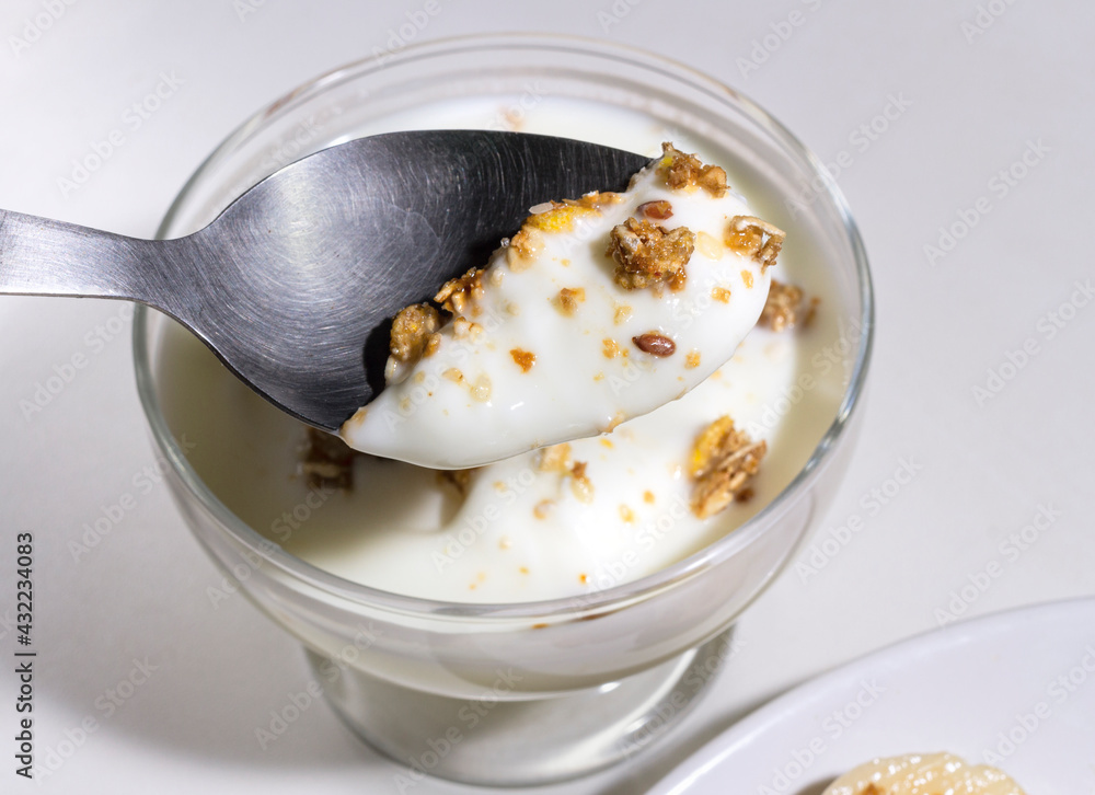 Full Spoon of homemade oatmeal granola and yogurt in a bowl. Healthy food. Concept of diet. Selective focus Full Spoon of homemade oatmeal granola and yogurt in a bowl. Healthy food. Concept of diet. Selective focus