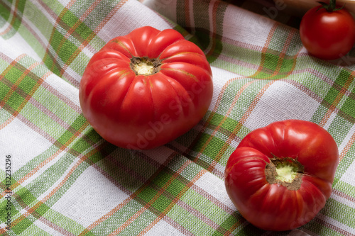 huge varietal irregularly shaped tomatoes on a napkin. Deformed vegetables. Household concept