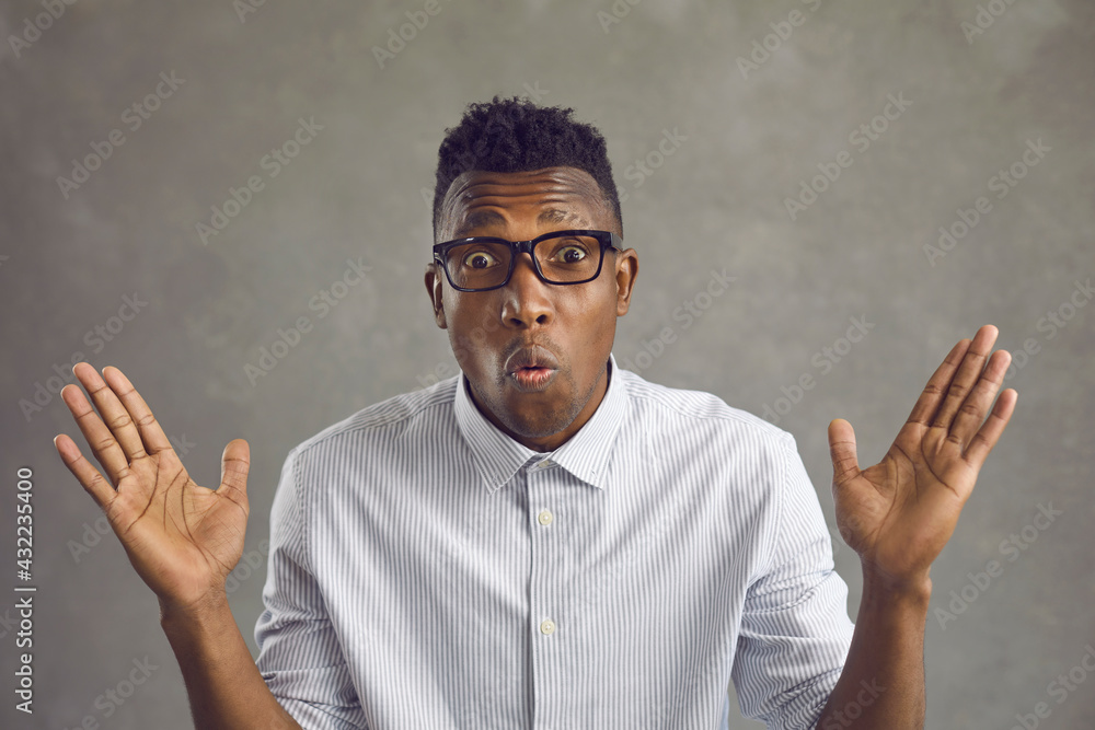 Studio portrait of excited black man in white shirt and eyeglasses