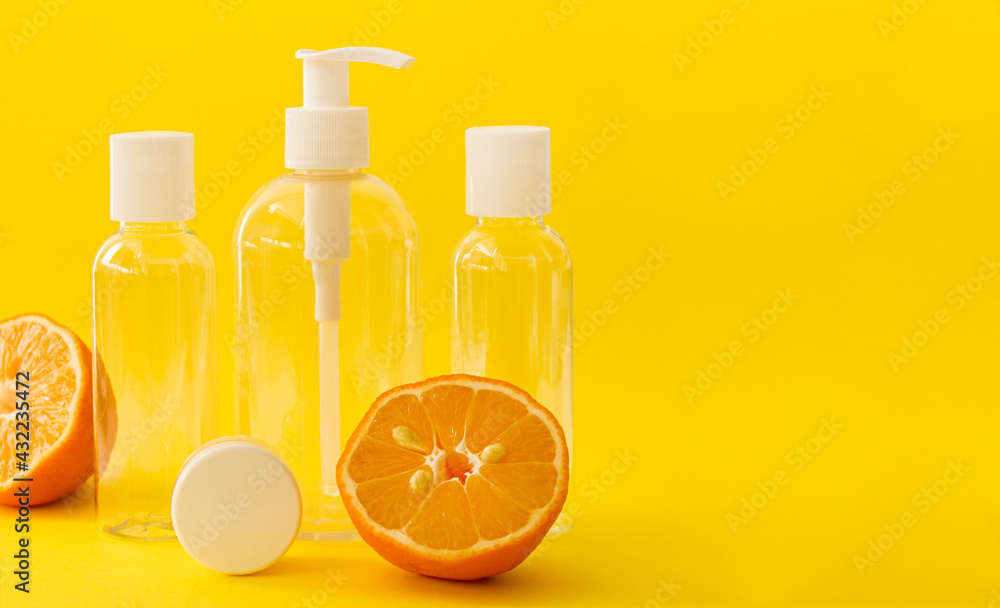 Plastic transparent cosmetic bottles with white cap and lemons on yellow background. Plastic transparent cosmetic bottles with white cap and lemons on yellow background.
