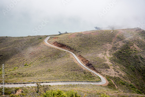 Hiking in the Marin Headlands with views of winding road ending with a foggy abyss.