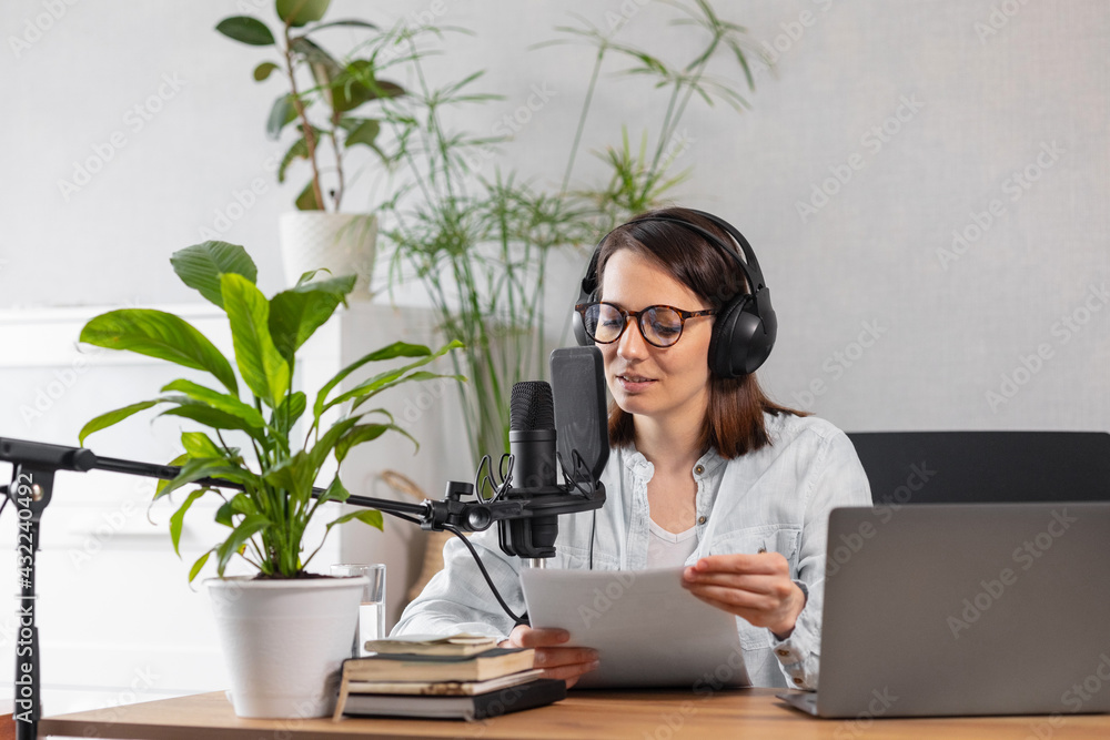 A fashionable European woman wearing headphones and a microphone records a podcast or radio show, a Caucasian woman creates audio content for her blog or podcast or records her voice for an audiobook A fashionable European woman wearing headphones and a microphone records a podcast or radio show, a Caucasian woman creates audio content for her blog or podcast or records her voice for an audiobook