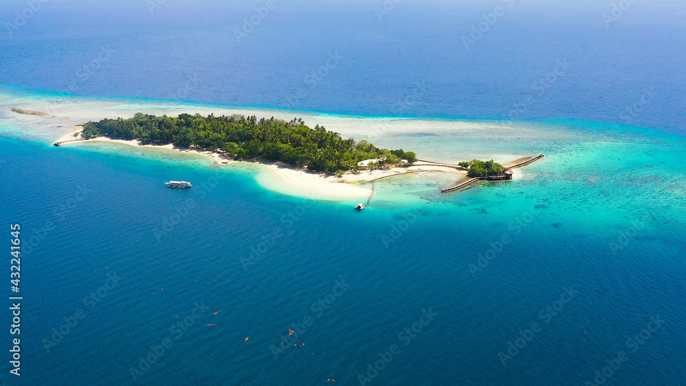 Top view of small tropical Little Liguid Island in the blue sea with a coral reef and the beach. Little Cruz Island, Philippines, Samal.