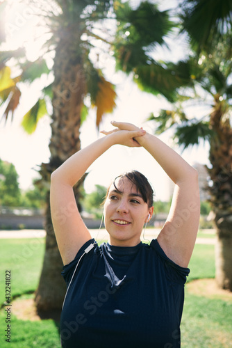a beautiful white woman with brown hair exercises her arms to be ready for physical activity 
