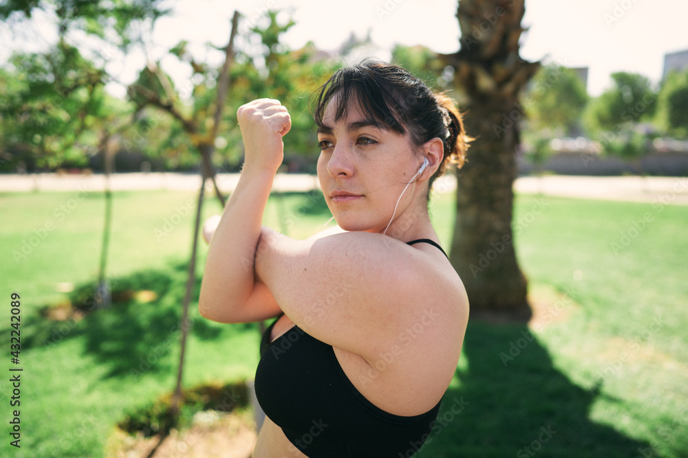 a beautiful white woman with brown hair exercises her arms to be ready for physical activity a beautiful white woman with brown hair exercises her arms to be ready for physical activity