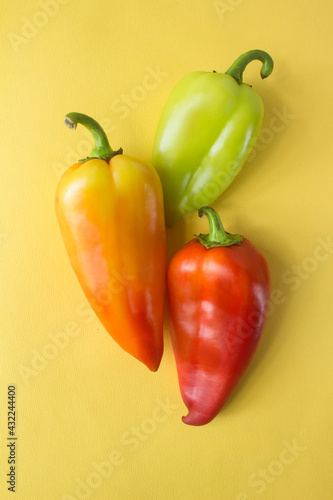 three different bell peppers on yellow . High quality photo