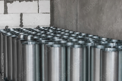 Pile of round metal pipes at a construction site. Storage steel tube industrial materials on warehouse