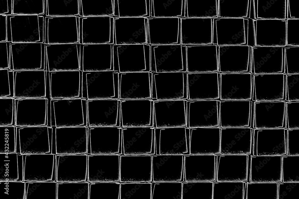 A pile of metal plates and square industrial pipes texture background. Building materials at the construction site A pile of metal plates and square industrial pipes texture background. Building materials at the construction site