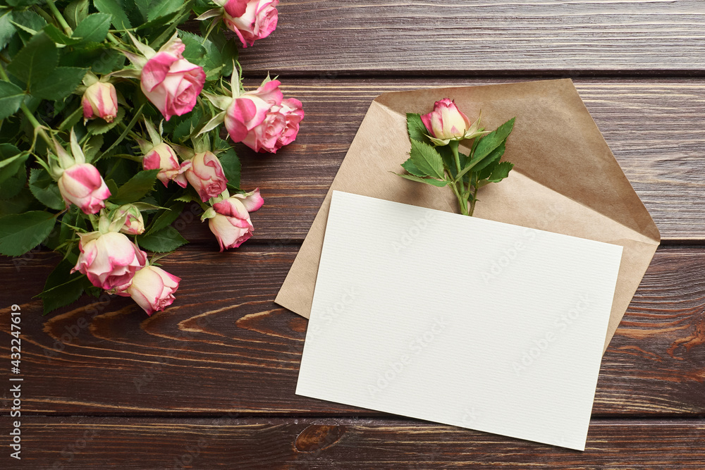 Greeting card with roses on dark wooden background, mockup with copy space Greeting card with roses on dark wooden background, mockup with copy space